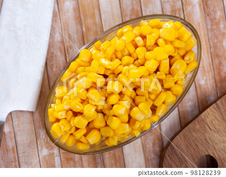 canned corn in bowl on wooden table canned corn in bowl on wooden table 98128239