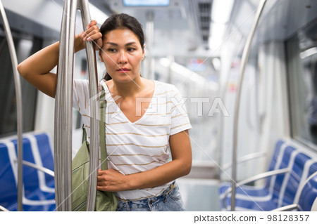 Overweary woman waiting for her stop in metropolitan train 98128357