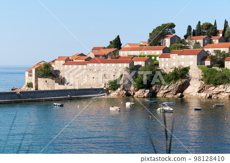 Calm blue sea and moored boats near the island of Sveti Stefan in Montenegro. Calm blue sea and moored boats near the island of Sveti Stefan in Montenegro. 98128410