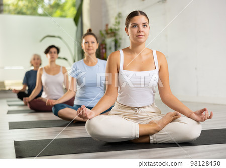 Group of woman making yoga meditation in lotus pose Group of woman making yoga meditation in lotus pose 98128450