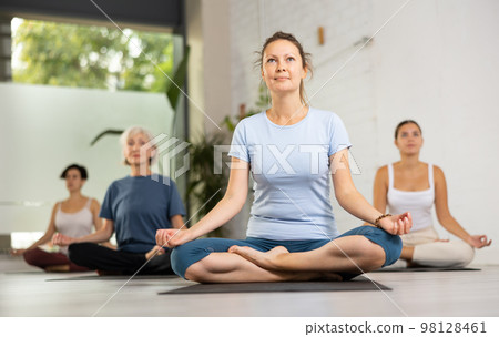 Young yogi girl making yoga meditation in lotus pose in fitness studio Young yogi girl making yoga meditation in lotus pose in fitness studio 98128461