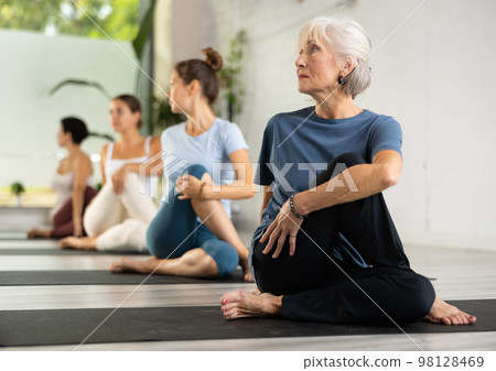 Group of sporty people practicing various yoga positions during training Group of sporty people practicing various yoga positions during training 98128469
