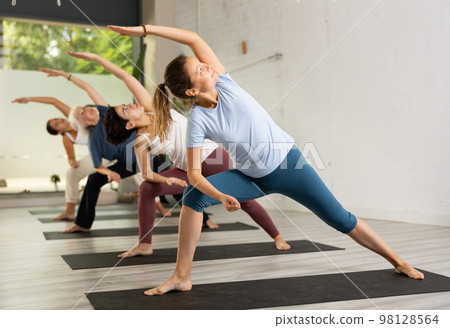 Women making yoga. Virabhadrasana pose Women making yoga. Virabhadrasana pose 98128564