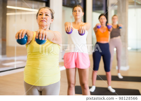 Mature female performing set of exercises with pilates ball Mature female performing set of exercises with pilates ball 98128566