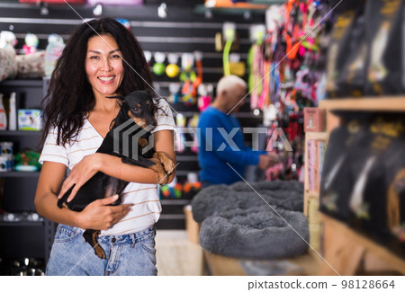 Woman with her dog in pet shop Woman with her dog in pet shop 98128664