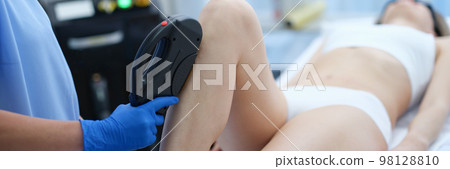 Laser hair removal of female legs in beauty salon Laser hair removal of female legs in beauty salon 98128810