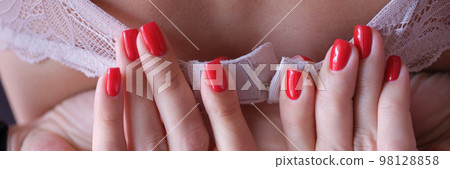 Woman fastens white lace bra on back 98128858