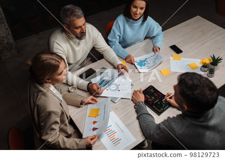 Diverse colleagues appreciate the presentation and discussing emotionally at contemporary office Diverse colleagues appreciate the presentation and discussing emotionally at contemporary office 98129723