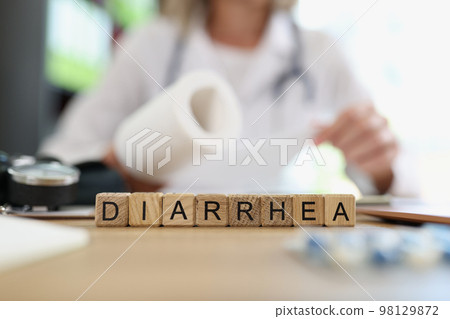 Blurred doctor with roll of toilet paper in hand and word diarrhea on table. Blurred doctor with roll of toilet paper in hand and word diarrhea on table. 98129872