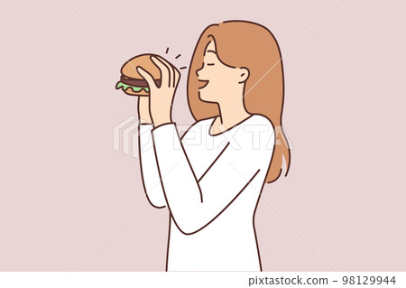 Happy woman eating hamburger  98129944