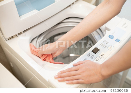 Hand of a woman cleaning the washing machine Hand of a woman cleaning the washing machine 98130086