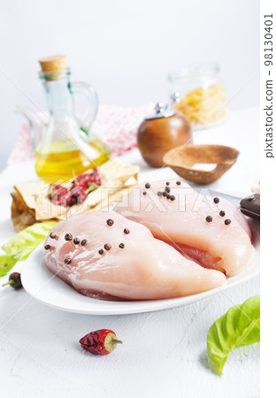 Raw sliced chicken breast fillet steaks on white plate 98130401