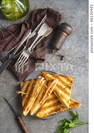 Classic club sandwich on a plate. The sandwich filling includes ham, cheese, lettuce, tomato slices Classic club sandwich on a plate. The sandwich filling includes ham, cheese, lettuce, tomato slices 98130485