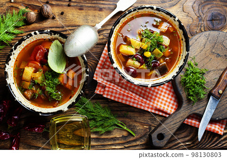 Chili soup in bowl with corn and been on dark background. Mexican cuisine. Top view 98130803