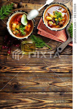 Chili soup in bowl with corn and been on dark background. Mexican cuisine. Top view 98130804