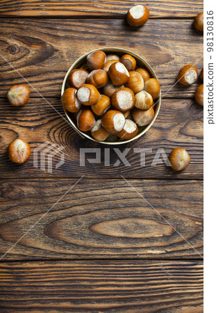 Hazelnuts on wooden backdrop. heap or stack of hazelnuts. Hazelnut background, healty food 98130816