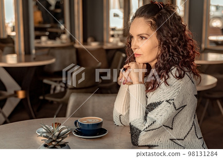 Woman cafe coffee breakfast. Portrait of an adult beautiful woman in an elegant suit in a cafe 98131284