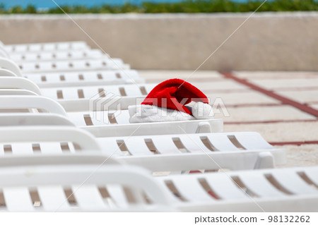 Santa Claus Hat on sunbed on caribbean sea background. Christmas and New Year vacation on the beach 98132262
