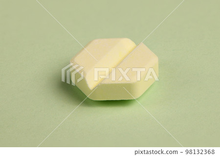 Hexagonal pills on light green background. Extreme closeup. 98132368