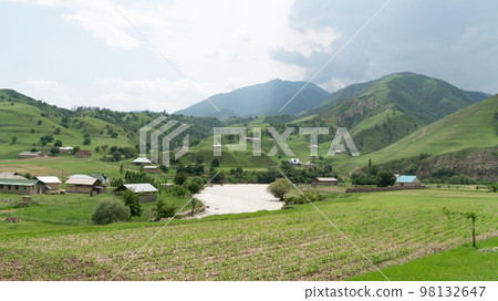 Kyrgyzstan nature green landscape with vast mountains. Kyrgyzstan is a landlocked country located in central Asia, known for its rugged, mountainous terrain and verdant grasslands. 98132647