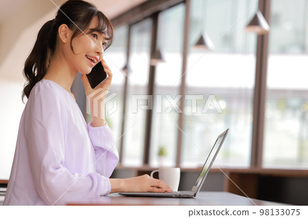 A young woman who speaks brightly on the phone_1 98133075