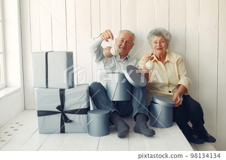 Grandparents at home. Old people with presents. Senior in a blue shirt. 98134134