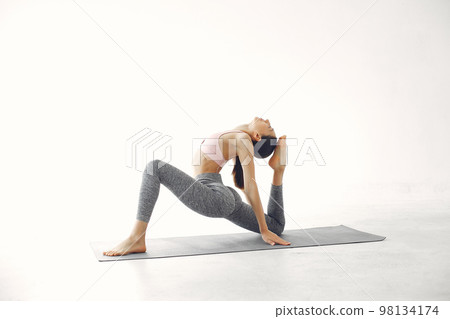 Beautiful girl in yoga studio. A woman doing a yoga. Lady in a pink top. 98134174