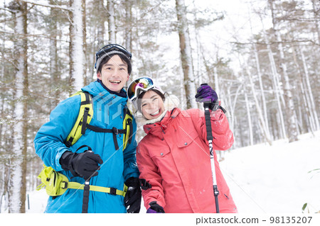 Couple enjoying snowshoes 98135207