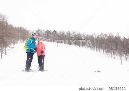Couple enjoying the snowy mountains 98135221