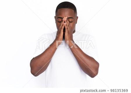 Displeased young man covering his face because of runny nose 98135369