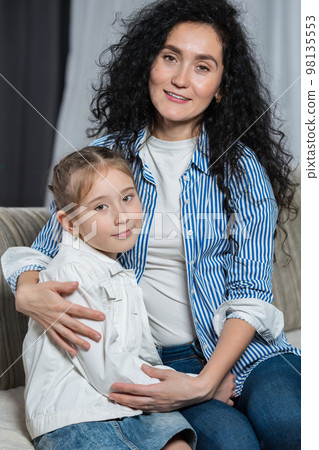 Mother demonstrates love to junior schoolgirl at home Mother demonstrates love to junior schoolgirl at home 98135553