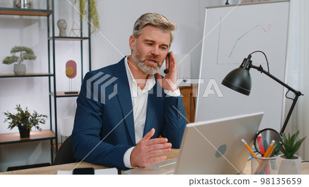 Businessman working on laptop wearing headset, call center support service operator office helpline 98135659