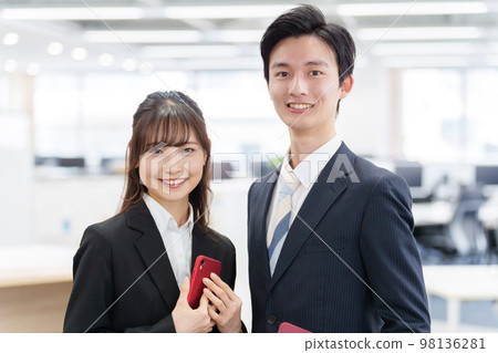Portrait of young man and woman relaxing in the office Portrait of young man and woman relaxing in the office 98136281
