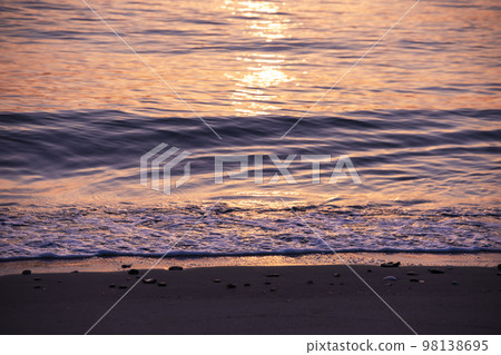 A sandy beach that glitters in the light of the rising sun A sandy beach that glitters in the light of the rising sun 98138695