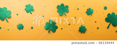 Happy St Patrick's Day decoration concept made from shamrocks ( clover leaf) and leprechaun hat on yellow background. 98139444