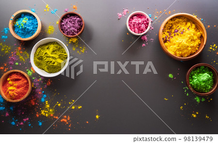 Happy Holi decoration, the indian festival.Top view of colorful holi powder on dark background. Happy Holi decoration, the indian festival.Top view of colorful holi powder on dark background. 98139479