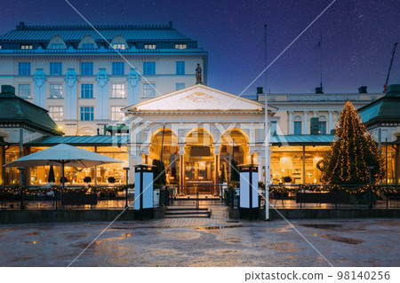 Helsinki, Finland. Colorful Night Dark Blue Starry Sky In Blue Colors With Sky Gradient. Famous Popular Place Is Cafe, Bar, Restaurant On Esplanadi Park In Lighting At Evening Or Night Illumination 98140256