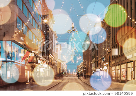 Helsinki, Finland. Light Blue Dramatic Sky. Night Boke View Of Aleksanterinkatu Street With Railroad In Kluuvi District In Evening Christmas Xmas New Year Festive Illumination. Bokeh Effect 98140599