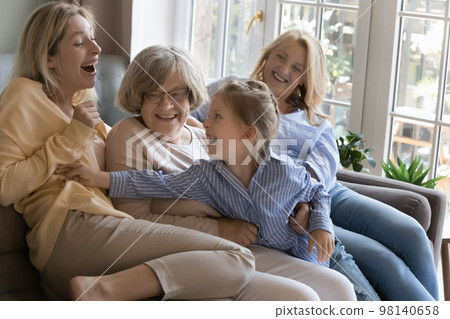 Cheerful female relatives having fun on home couch 98140658