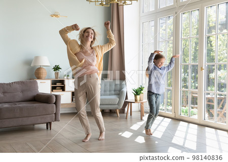 Excited energetic young mom and kid girl holding hands 98140836