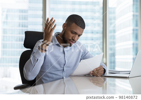 Frustrated African man read bad news in postal letter Frustrated African man read bad news in postal letter 98140872