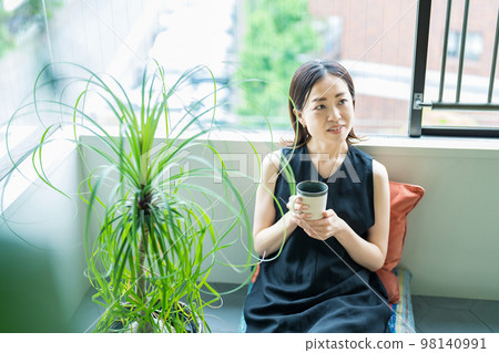 一個被觀葉植物包圍的女人 98140991