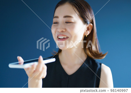 A woman talking on a smartphone A woman talking on a smartphone 98140997