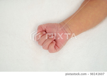 Close up newborn baby hand on bed Close up newborn baby hand on bed 98141607