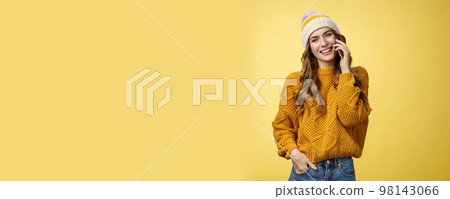 Charming stylish european woman wearing hat sweater tilting head flirty smiling talking smartphone calling boyfriend consulting friend via cellphone, standing happily casual pose yellow background Charming stylish european woman wearing hat sweater tilting head flirty smiling talking smartphone calling boyfriend consulting friend via cellphone, standing happily casual pose yellow background 98143066