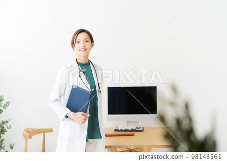 Female doctor standing in examination room Female doctor standing in examination room 98143561