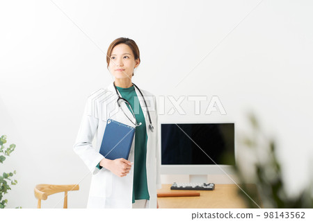 Female doctor standing in examination room Female doctor standing in examination room 98143562