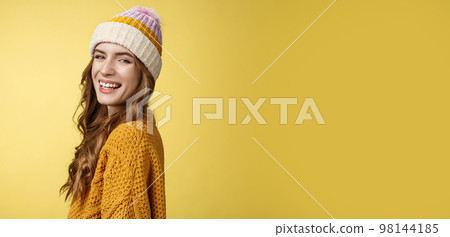 Profile shot charming carefree happy smiling girl turning camera grinning joyfully enjoying winter vacation having fun skiing, standing amused laughing wearing hat knitted sweater yellow background 98144185