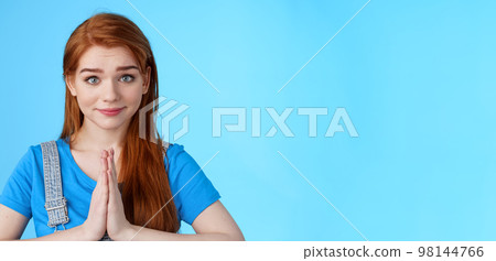 Close-up attractive tender redhead woman asking pretty please, supplicating, hold hands pray, namaste gesture, look sincere pity, smiling begging help favor, stand blue background Close-up attractive tender redhead woman asking pretty please, supplicating, hold hands pray, namaste gesture, look sincere pity, smiling begging help favor, stand blue background 98144766