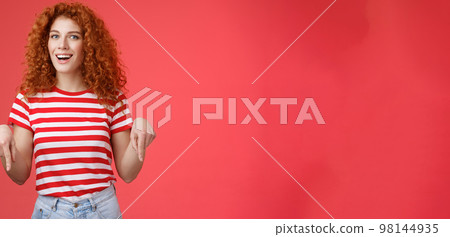 Hey check it out friend. Sassy good-looking cheeky redhead stylish girlfriend curly hairstyle wear summer t-shirt pointing down index finger smiling amused delighted present awesome recommendation Hey check it out friend. Sassy good-looking cheeky redhead stylish girlfriend curly hairstyle wear summer t-shirt pointing down index finger smiling amused delighted present awesome recommendation 98144935